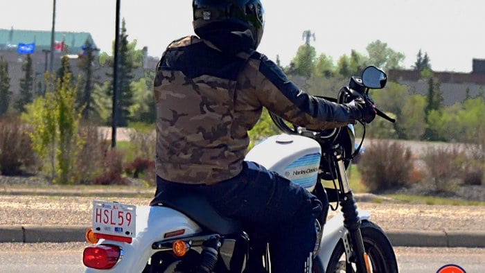 Rider in Camo on top Harley Davidson Motorcycle