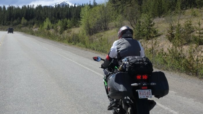 2018 Kawasaki Ninja H2SXSE riding down the road, viewed from behind.