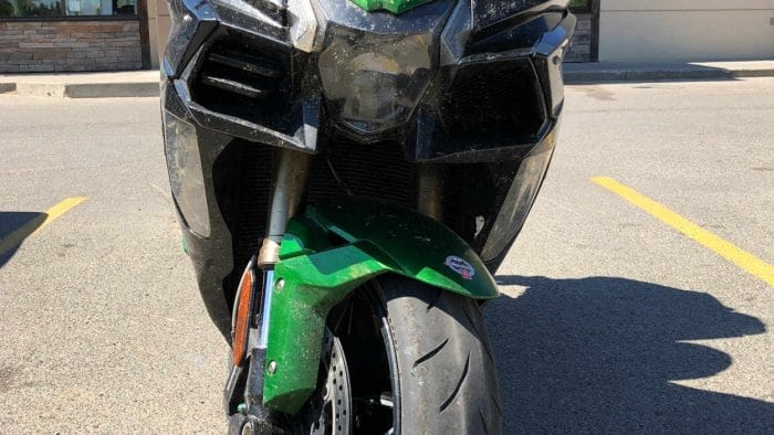 A very dirty 2018 Kawasaki Ninja H2SX SE in a parking lot.