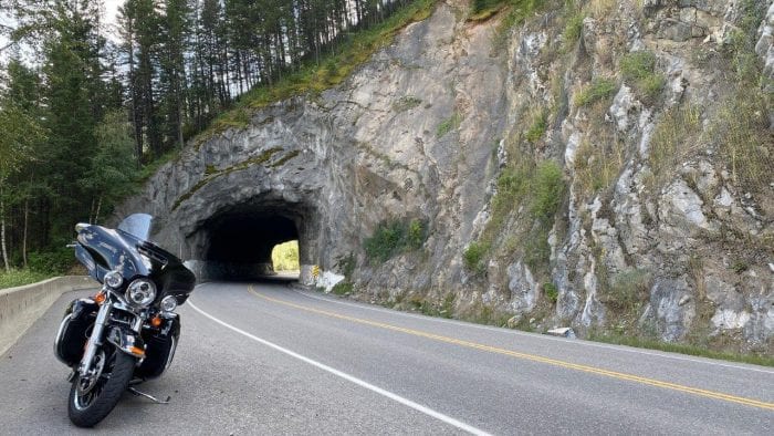 A Harley Davidson parked in front of a tunnel.