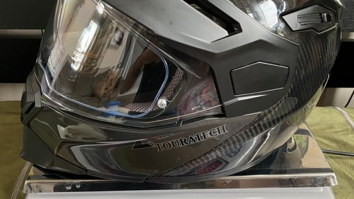 The Touratech Aventuro Traveller Carbon helmet on a scale (in pounds).