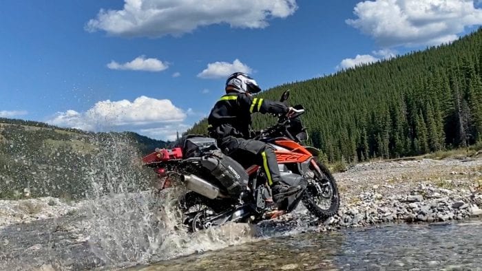 Jim Pruner riding his KTM 790 Adventure through water while wearing the Arai XD-4 helmet.