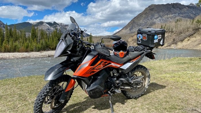 The Klim Krios Pro helmet sitting on a KTM 790 Adventure by a stream.