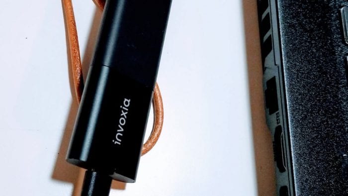 Invoxia GPS tracker getting charged with a micro USB charging cable.