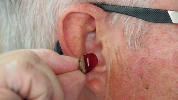 A man inserting a hearing aid