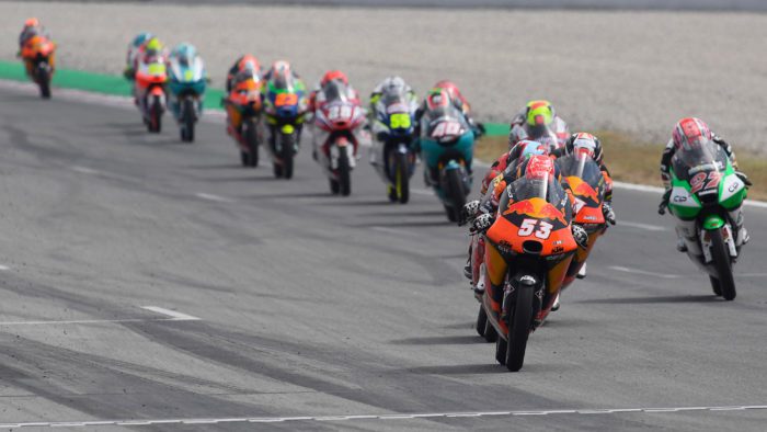 a lineup of Moto3 machines on a sharp turn.