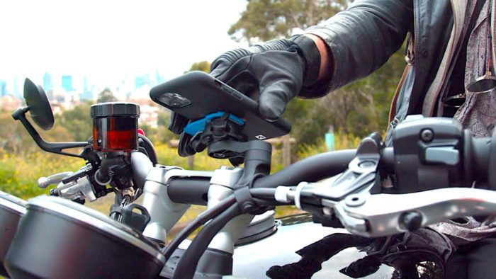 A view of a rider trying out the QuadLock phone mount with the optional vibration Damper