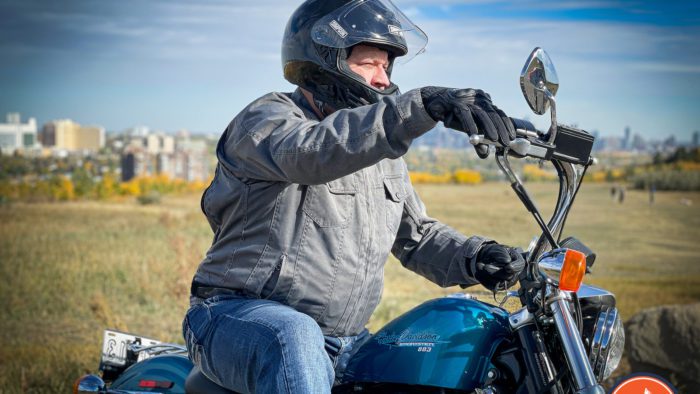 A view of the WBW reviewer trying out the Rev'it Echo Gloves holding the bars of his Harley Davidson Sportster, and wearing a Simpson Speed Bandit helmet.