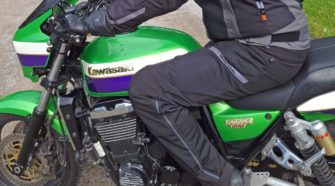 Rider wearing Richa Softshell WP Pants on green Kawasaki motorcycle