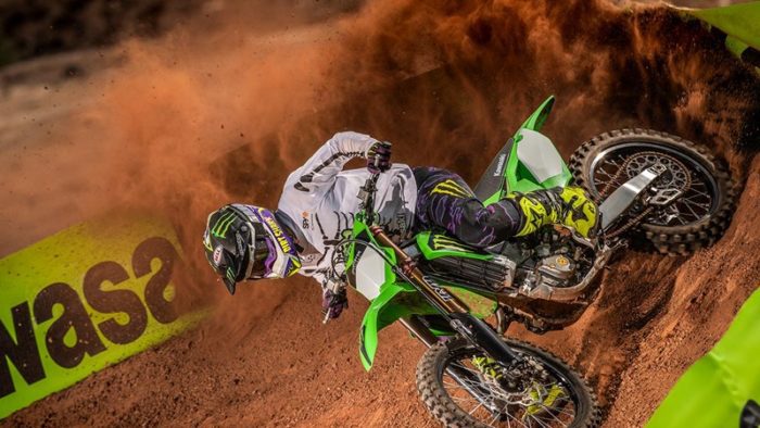 A side profile of a rider trying out the new 2022 Kawasaki KX450SR edition on a track