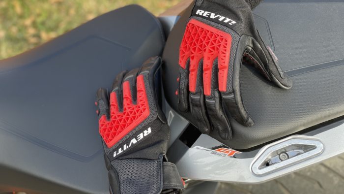 REV'IT Sand 4 Gloves in black and red lying on seat of motorcycle