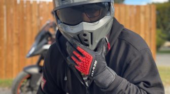 Rider wearing REV'IT Sand 4 Gloves in black and red with Scorpion Covert X helmet