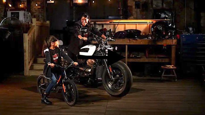 A view of a rider on the Harley-Davidson Sportster, with a child looking up to the big bike
