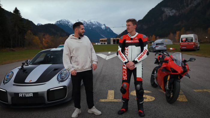 A view of Daniel Abt and a motorcyclist trying out a quarter-mile drag race between a Ducati Panigale V4 S and a Porsche GT2 RS