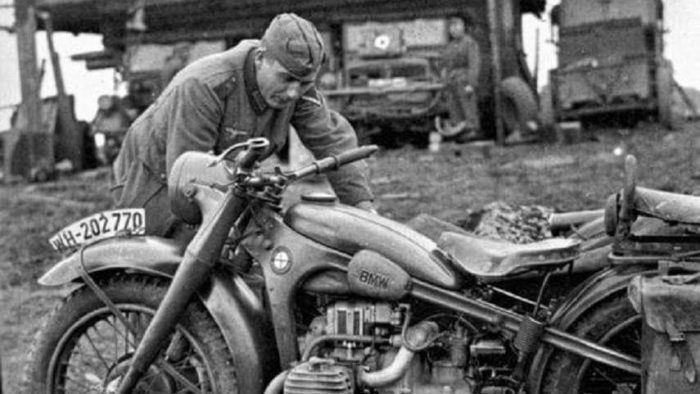 A german soldier tends to his BMW motorcycle during WWII