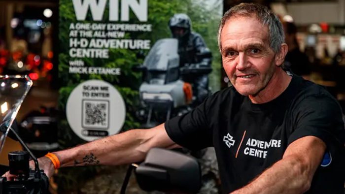 A view of Mike Extance with an advert in the background