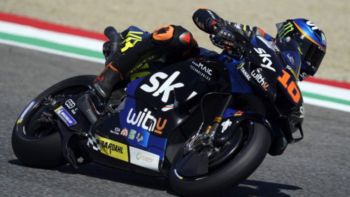 A side view of a racer in the MotoGP grid, racing his motorcycle